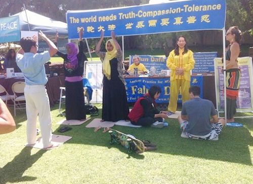 第二十五届美国加州圣地亚哥地球日街市上,络绎不绝的民众来到法轮功展位前学功
