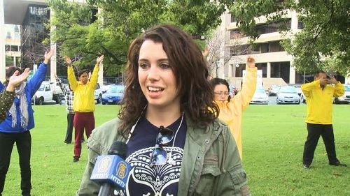图说:南澳大学国际贸易学生莎莉被法轮功学员炼功场面的巨大能量所吸引