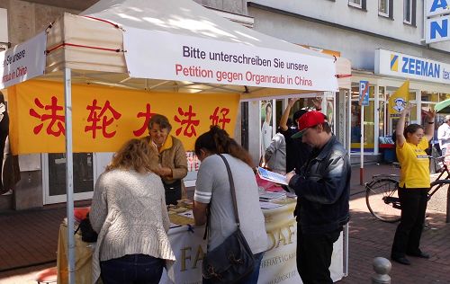 图2:多特蒙德第十六届国际文化周上,人们在法轮功展位签名声援反迫害
