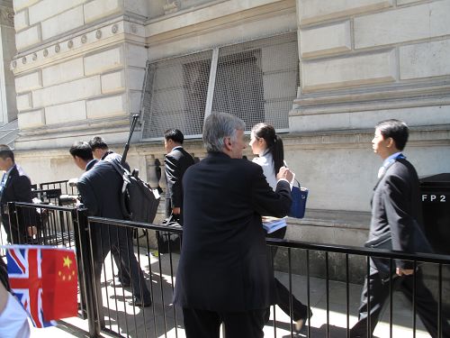 图5:西人法轮功学员泽克用简单汉语告诉李克强的随从人员法轮大法好,并劝他们退党。