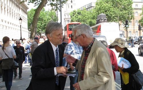 法轮功学员在英国首相府前,跟前来看热闹的人们讲述法轮功的真相。
