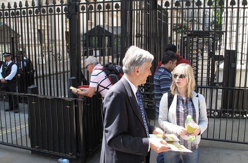 法轮功学员在英国首相府前,跟前来看热闹的人们讲述法轮功的真相。