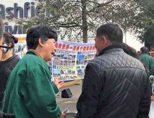 图2-5:图文并茂的真相图片吸引了过往民众的目光,许多人停下脚步,倾听法轮功学员讲述真相。