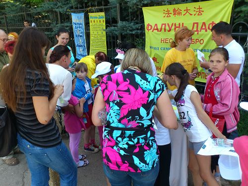 孩子们学折纸莲花,家长们阅读法轮功真相资料