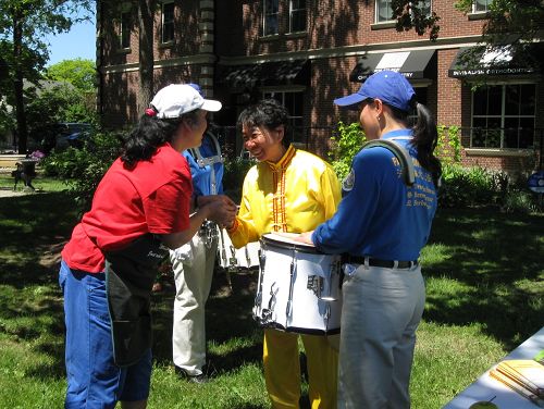 菲律宾裔义工Marie抓住腰鼓队成员付女士的手说:“你们一定要把这个传统的东西在世界弘扬。”