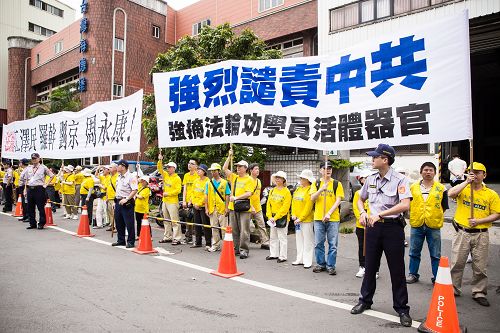 图4、5、6:中共国台办主任张志军二十六日在新北市五股区与新北市长朱立伦会面,法轮功学员高举“强烈谴责中共强摘法轮功学员器官”横幅。