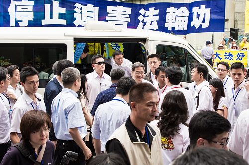图7:中共国台办主任张志军等人在新北市五股区参访饼家,法轮功学员高举“停止迫害法轮功”横幅。