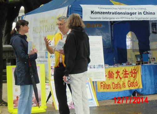 瑞士旅游胜地卢塞恩的天鹅湖畔,路人听法轮功学员讲真相