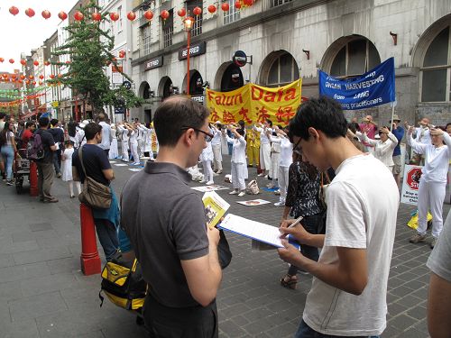 在伦敦唐人街,游人签名支持法轮功反迫害