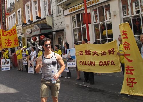 在伦敦唐人街,路人在真相横幅前留影,支持法轮功