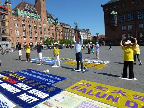 学员们在市政厅广场上拉开横幅和展板,并展示功法