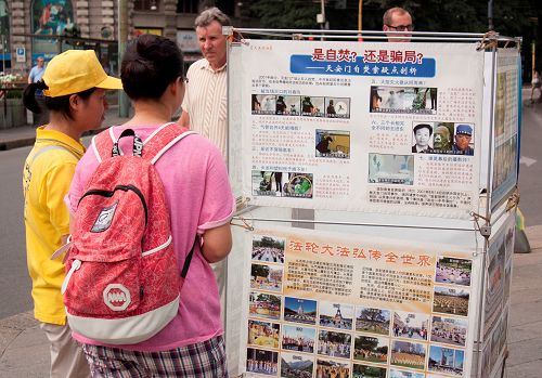 图4:中国游客阅读展板,了解“天安门自焚”真相