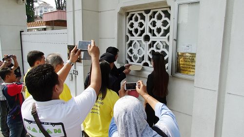 法轮功学员递交抗议信于中共驻马大使馆,引起了许多警官的关注。