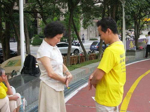 图9:廖女士认真跟法轮功学员学炼动作