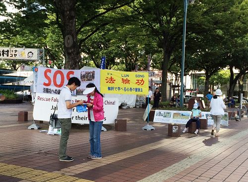 在爱知县名古屋市最繁华地段之一的荣(Sakae),行人在反中共活摘法轮功学员器官的签名簿上签字。