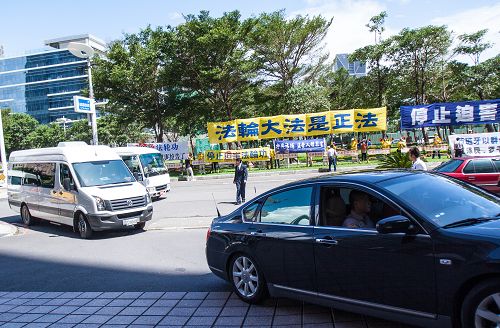 二十五日强卫一行车队到达最后一站高雄军鸿酒店,法轮功学员聚集一波波的谴责声浪,强卫一行快步闪入酒店,狼狈不堪。