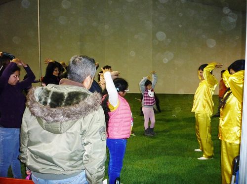 图6-7:游客在利马举行的家居博览会上现场学炼法轮功