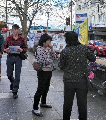 图2:法轮功学员秀琴(右)帮助华人明真相、做“三退”