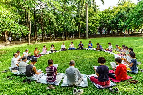 在台南东宁公园中央大草地上,法轮功学员炼完五套功法后,继续一起学法一个半小时。