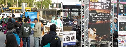 图2-3:“中共活摘法轮功学员器官”模拟演示行动剧吸引车上乘客、摩托车骑士以及熙来攘往的民众聚焦注目。