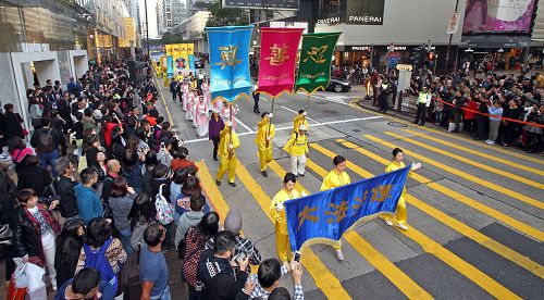 法轮功阵容庞大整齐的游行队伍吸引中西游客及港民驻足观看,纷纷举起相机、手机拍照。