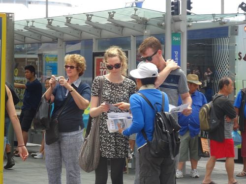 图2:人们驻足倾听法轮功学员讲述真相