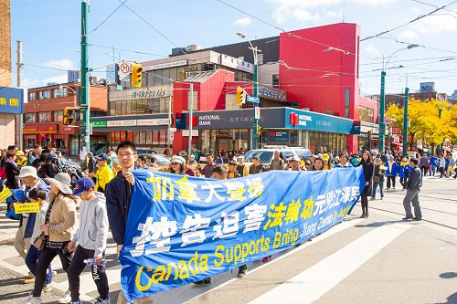 图1-9:二零一五年十月十日中午,多伦多法轮功学员在市中心举行今年诉江以来的第二次诉江大游行,所到之处引起民众的关注,很多民众表示支持并在制止活摘的请愿信上签名。