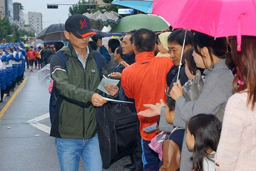 图8:观众从发真相学员的手中接阅真相传单