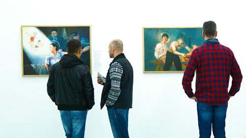 图2:展出的作品揭露中共对法轮功学员的酷刑折磨,让很多观众深受触动。