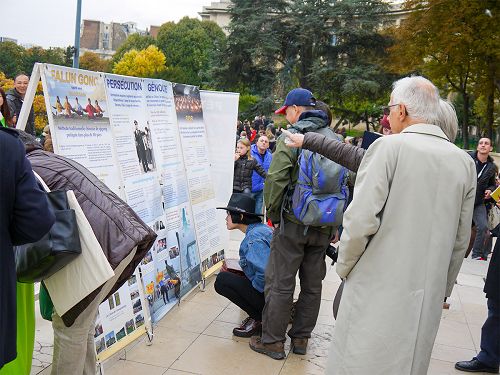 图2-5:巴黎艾菲尔铁塔下,游客认真阅读法轮功真相展板