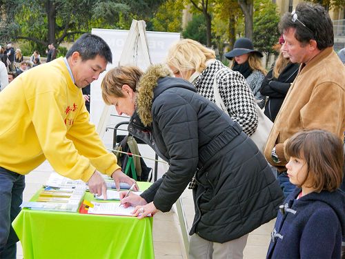 图6:巴黎艾菲尔铁塔下,游客前面谴责中共迫害法轮功