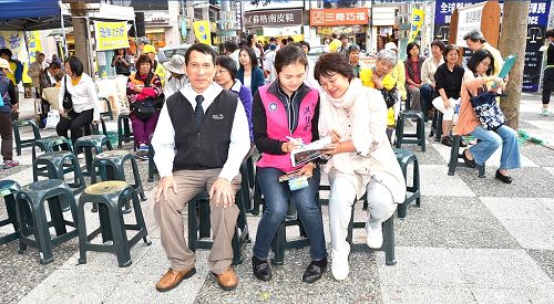 图说3:市议员洪佳君(中)在现场签署举报书,声援诉江