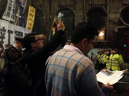 图5:二零一五年十月二十一日晚,在一家风险投资公司工作的拉吉(Raj)认真阅读法轮功真相传单,并和站在旁边的法轮功学员交谈,深入了解真相