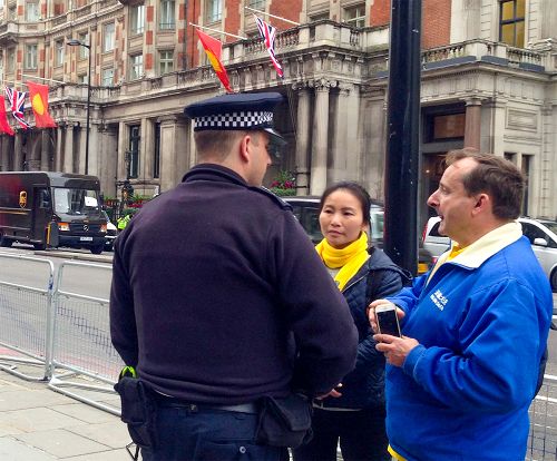 图11:二零一五年十月二十二日下午,法轮功学员在结束文华东方酒店(Mandarin Oriental Hyde Park)活动后,一位当天担任执勤任务的警察与两位法轮功学员友好对话