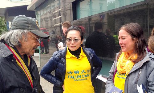 图8:二零一五年十月二十二日,在伦敦市中心繁华地带骑士桥(Knightbridge)地区的街头,拉夫(Raf)在谴责活摘的征签表上签下自己的名字,之后他与法轮功学员愉快交谈,希望进一步了解法轮功