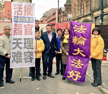 图2:二零一五年十月二十三日,曼城市议员凯文·皮尔 (Kevin Peel) 先生赶到法轮功学员在曼城市政厅近旁和平请愿的队伍中表支持