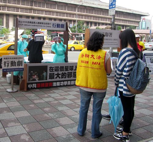 图1:台北法轮功学员在台北车站商圈以模拟演示行动剧,揭露中共暴行