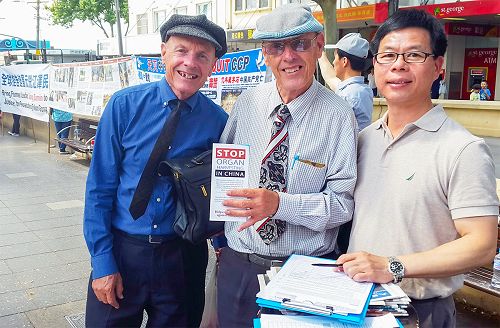 图7:瑞盛先生(Rodney Rasion )和朋友(Robert )罗伯特在真相摊位前和法轮功学员合影。