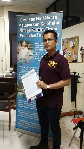 图:雅加达法律援助机构主任阿克萨(Alghifari Aqsa)签名后表示希望法轮功学员让更多人了解真相