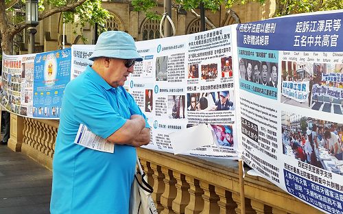 图:迈克尔·麦凯布(Michael Mccabe)先生一直驻足在展板前了解真相。