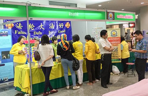 图1-2:参观者在法轮功展位索拿取资料,请购大法书籍,了解真相