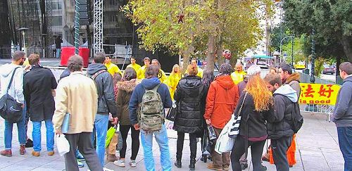 图1-2:二零一五年十二月十一日,希腊法轮功学员在市中心宪法广场上介绍功法,征签诉江