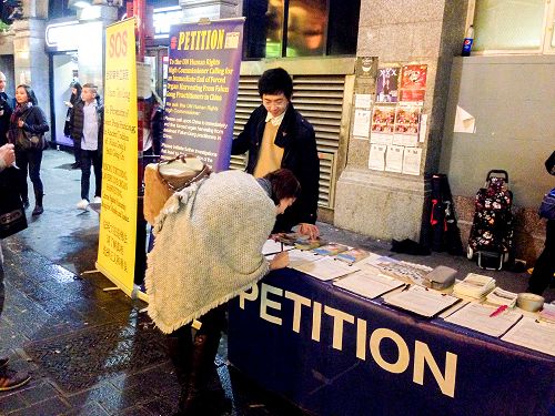 图3:二零一五年十一月七日,来自保加利亚的安东尼娅女士和丈夫来到唐人街真相点,在谴责中共活摘法轮功学员器官罪行的征签表上签名。
