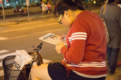 图9:一位女孩正在阅读刚拿到的真相材料。