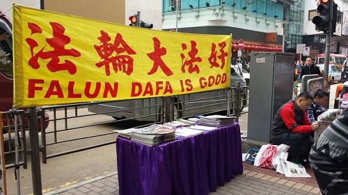 在流动真相点,大陆游客接过真相特刊后,就坐到一旁阅读。