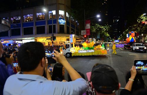 法轮功方阵经过之处,吸引了众多观众拍照摄影