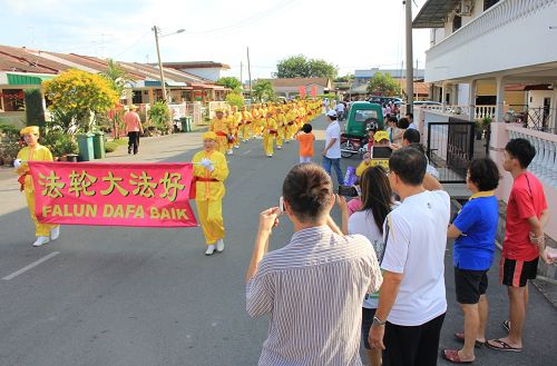 法轮功学员来到了彭亨州直凉举行新年游行,吸引了许多民众追随观看。