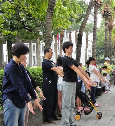 图6:两旁行人道上民众跟着炼法轮功第一套功法。