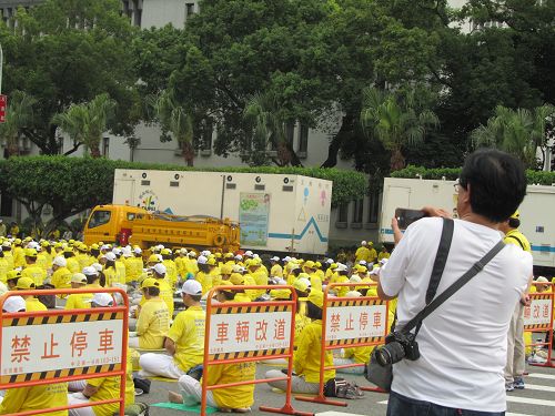 图4:壮观的炼功场面吸引民众拍照。