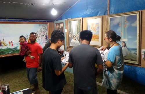图1-6:“真善忍国际美展”来到塞班岛火树节,每天都有大批的民众驻足聆听法轮功学员的讲解